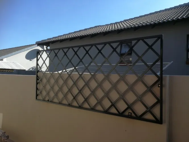 A long diamond trellis panel made to fit along the top of a boundary wall